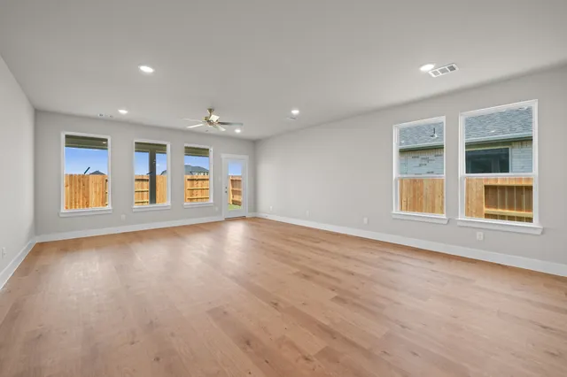 an empty room with windows and chandelier