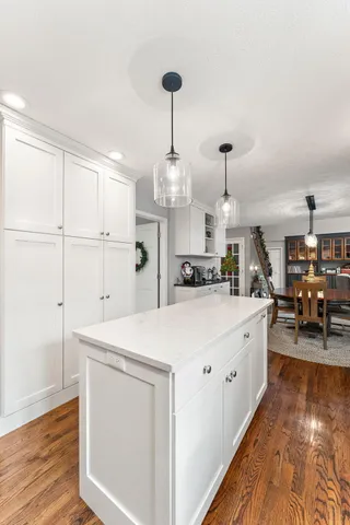 a large white kitchen with wooden floor