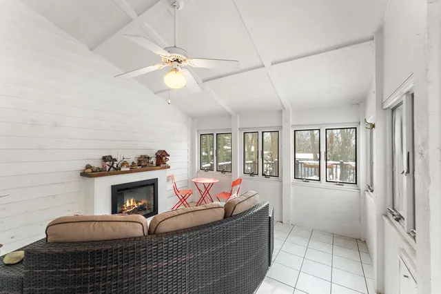 a living room with furniture a fireplace and a ceiling fan