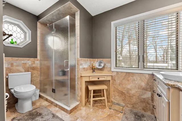 a bathroom with a granite countertop sink a toilet and shower