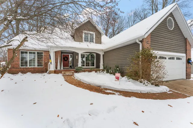 a view of a white house with a large tree