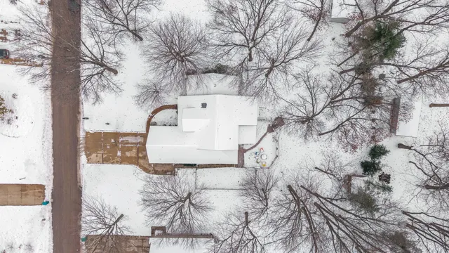 a front view of a house with a yard covered in snow