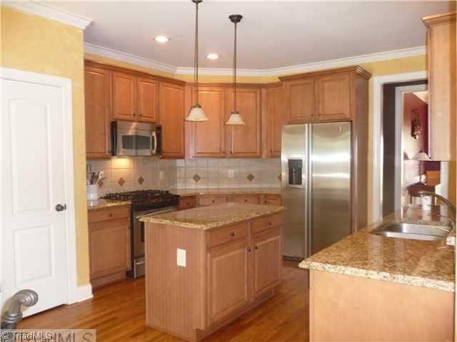 8914 Grove Park Drive Oak Ridge, NC 27310 - Photo 6 of 16 Kitchen. Plenty of work space in this custom kitchen including granite countertops, decorator backslpash, 42" custom cabinets and SS appliances.