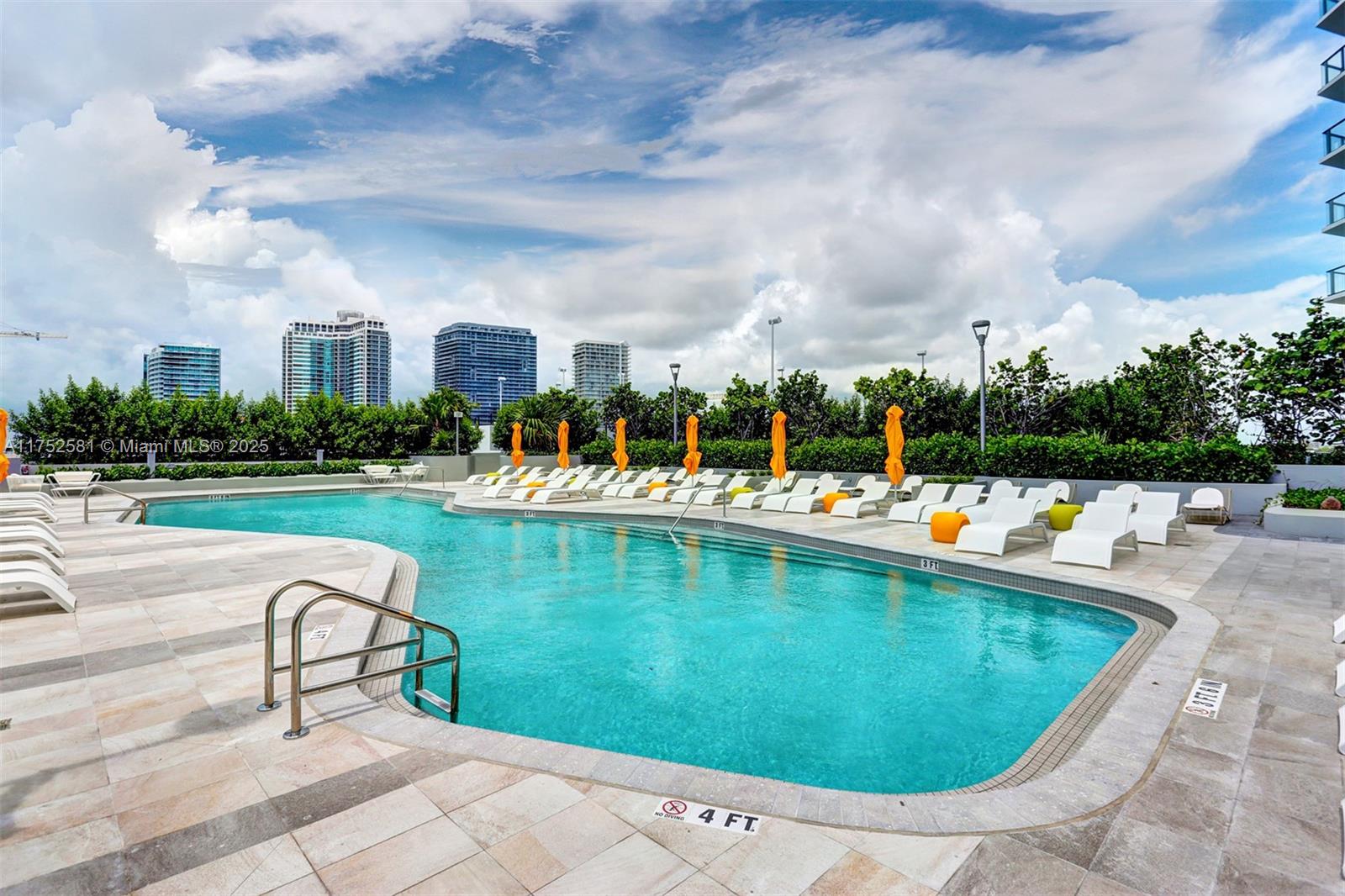 501 Northeast 31st Street, Unit 910 Miami, FL 33137 - Photo 30 of 84 a view of swimming pool that has lawn chairs with plants and trees in the background
