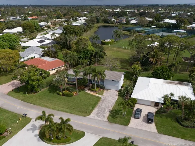 an aerial view of a house with garden space and lake view
