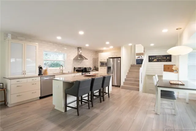 a kitchen with a dining table chairs and refrigerator