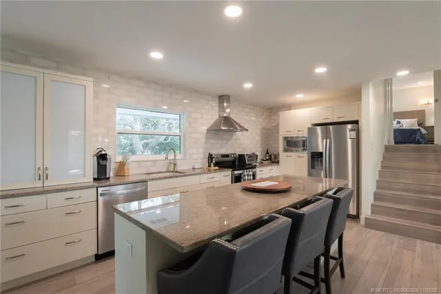 a kitchen with granite countertop kitchen island cabinets and refrigerator