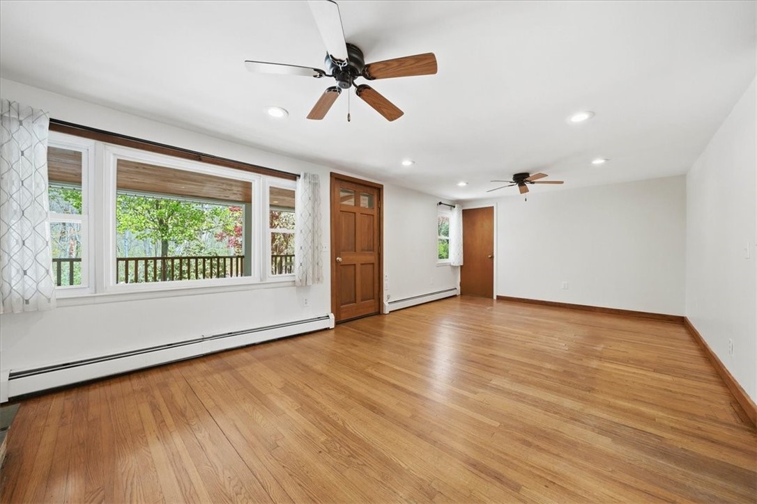 322 Rocky Hill Road Scituate, RI 02857 - Photo 10 of 50 Spacious and bright living room featuring gleaming hardwood floors, recessed lighting, and a classic brick fireplace with wood mantel as a warm focal point. Far left corner is the convenient 1st floor laundry room with stacked Washer & Dryer.