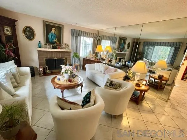 119 Linaza Lane Spring Valley, CA 91977 - Photo 4 of 36 a dining room with furniture a rug a fireplace and a chandelier