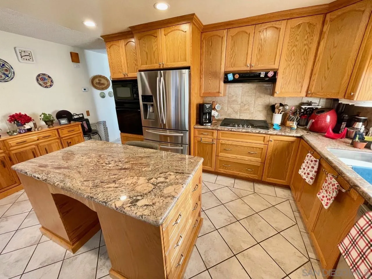 119 Linaza Lane Spring Valley, CA 91977 - Photo 6 of 36 a kitchen with stainless steel appliances granite countertop a sink refrigerator and microwave