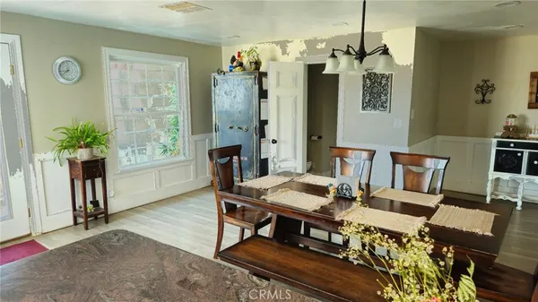 a dining room with furniture a chandelier and wooden floor