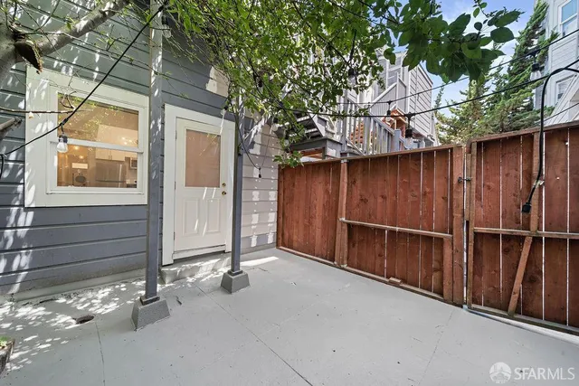 a view of backyard with tub and wooden fence