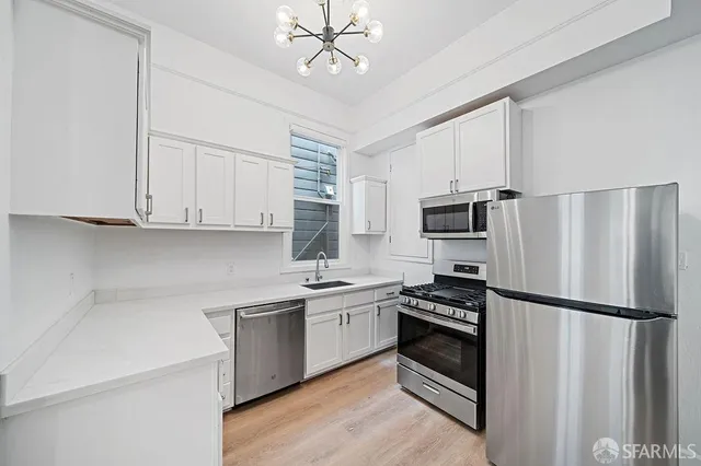 a kitchen with stainless steel appliances a refrigerator sink and microwave