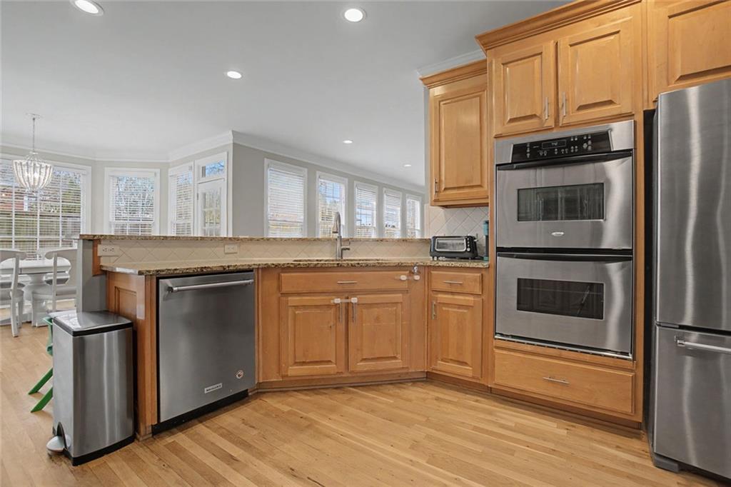 2018 Cockrell Pointe Northwest Kennesaw, GA 30152 - Photo 11 of 51 a kitchen with granite countertop a refrigerator stove and wooden floor