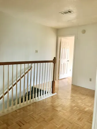 a view of staircase with railing and a rug