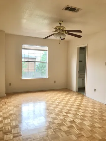 an empty room with windows and fan