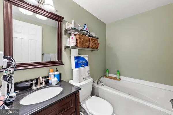 a bathroom with a sink vanity mirror and toilet