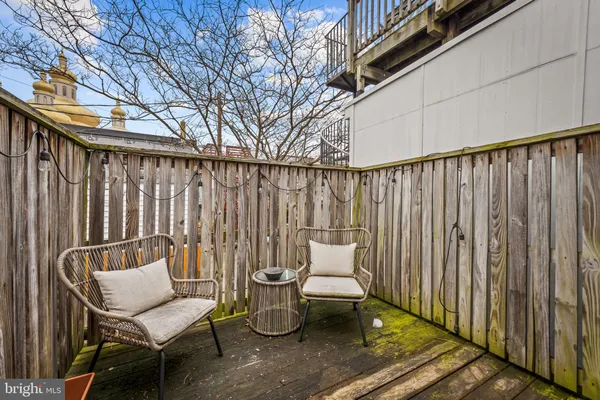 a balcony with wooden chairs and a fire pit