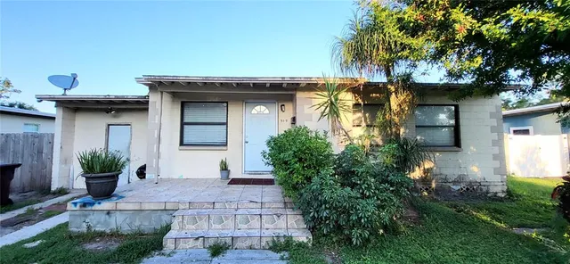 a front view of a house with plants
