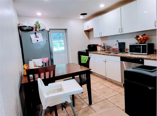 a kitchen with a dining table cabinets and appliances
