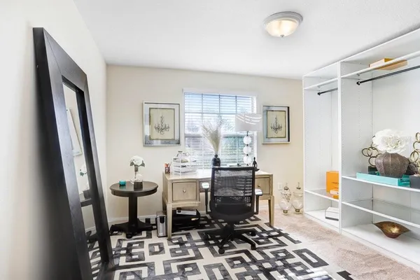 a room with chairs and view of kitchen