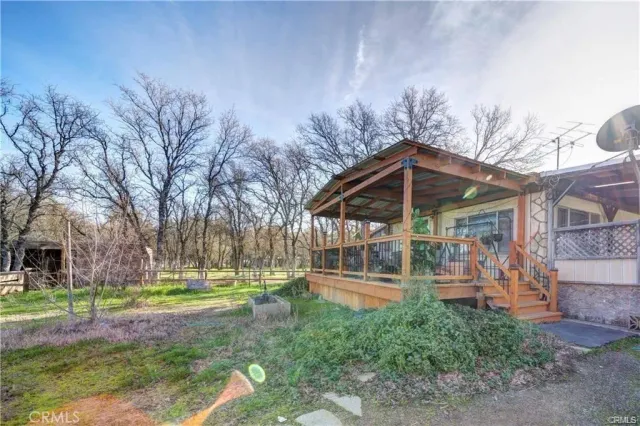 a view of a house with backyard and trees