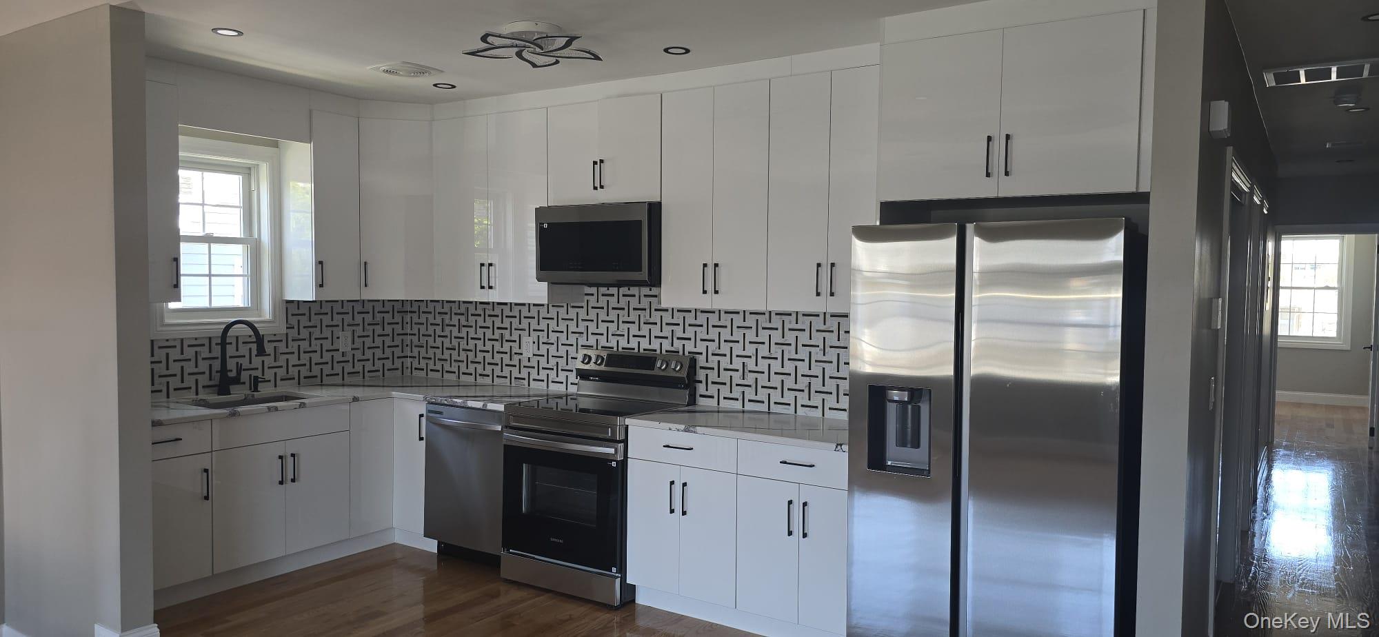 108-33 164th Street Queens, NY 11433 - Photo 13 of 20 a kitchen with stainless steel appliances a refrigerator sink and microwave