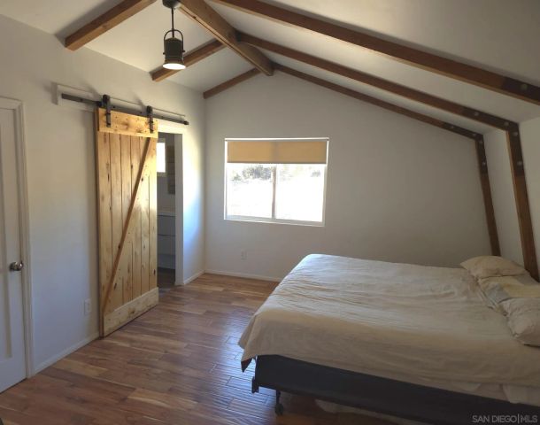 a bedroom with a bed and a window