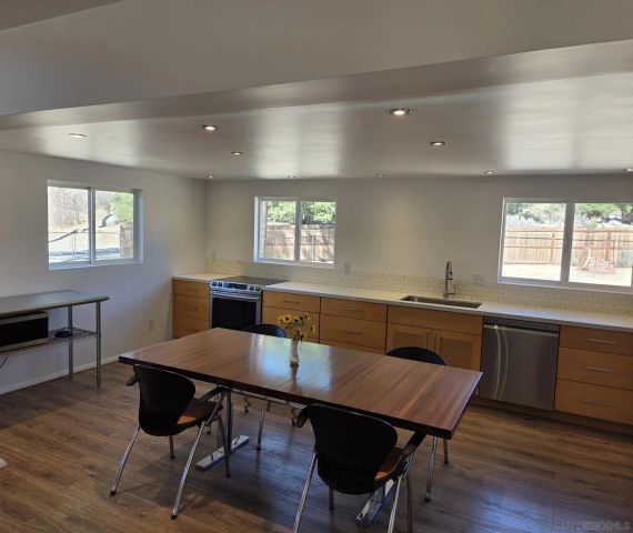 a kitchen with a table chairs and wooden floor