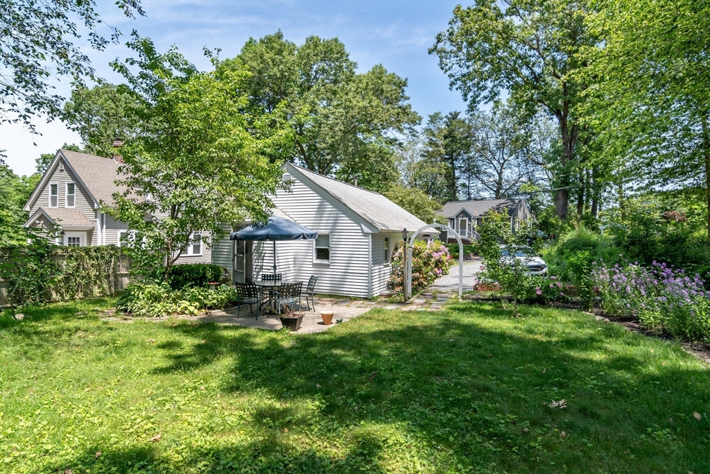 62 Sycamore Road Wayland, MA 01778 - Photo 16 of 16 a backyard of a house with table and chairs