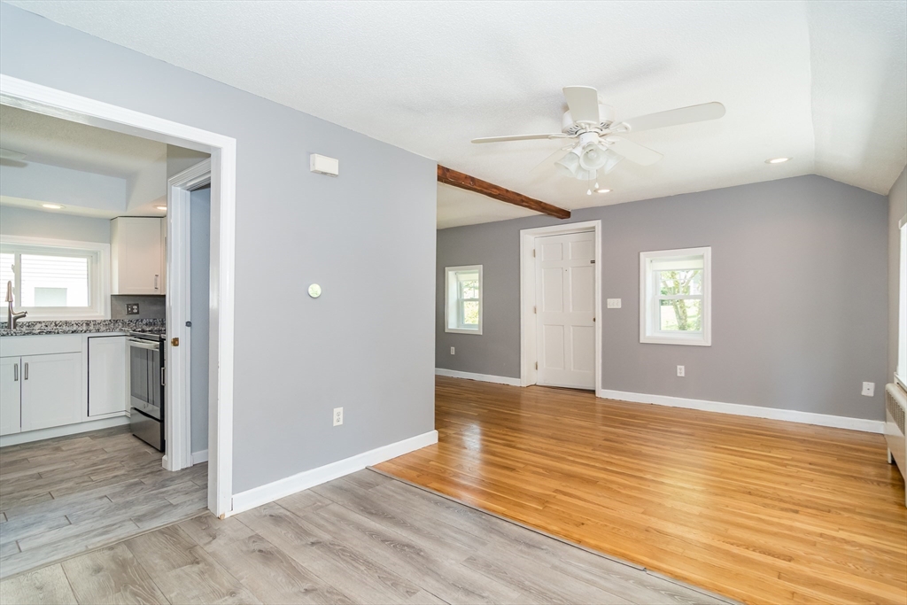 62 Sycamore Road Wayland, MA 01778 - Photo 3 of 16 a view of an empty room with wooden floor and a kitchen