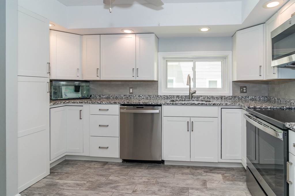 62 Sycamore Road Wayland, MA 01778 - Photo 5 of 16 a kitchen with granite countertop cabinets stainless steel appliances a sink and a window