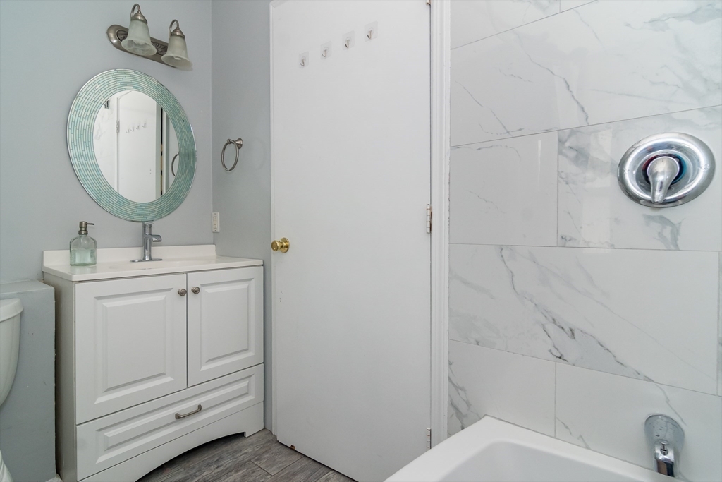62 Sycamore Road Wayland, MA 01778 - Photo 7 of 16 a bathroom with a toilet sink vanity and mirror