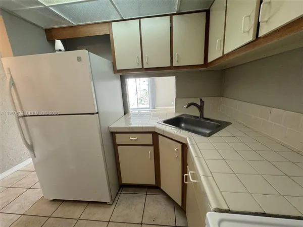a kitchen with a refrigerator and a sink
