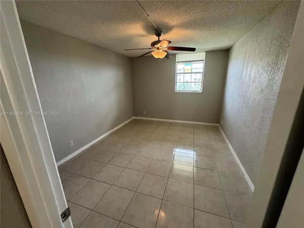 a view of a livingroom with a chandelier fan and wooden floor