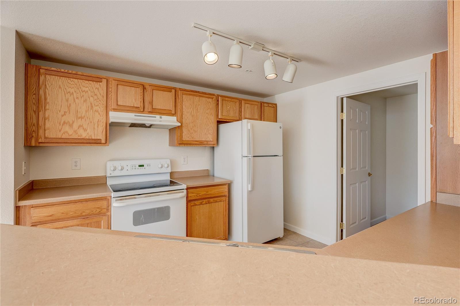 5756 North Genoa Way, Unit 12208 Aurora, CO 80019 - Photo 12 of 33 a kitchen with refrigerator a stove a washer and dryer