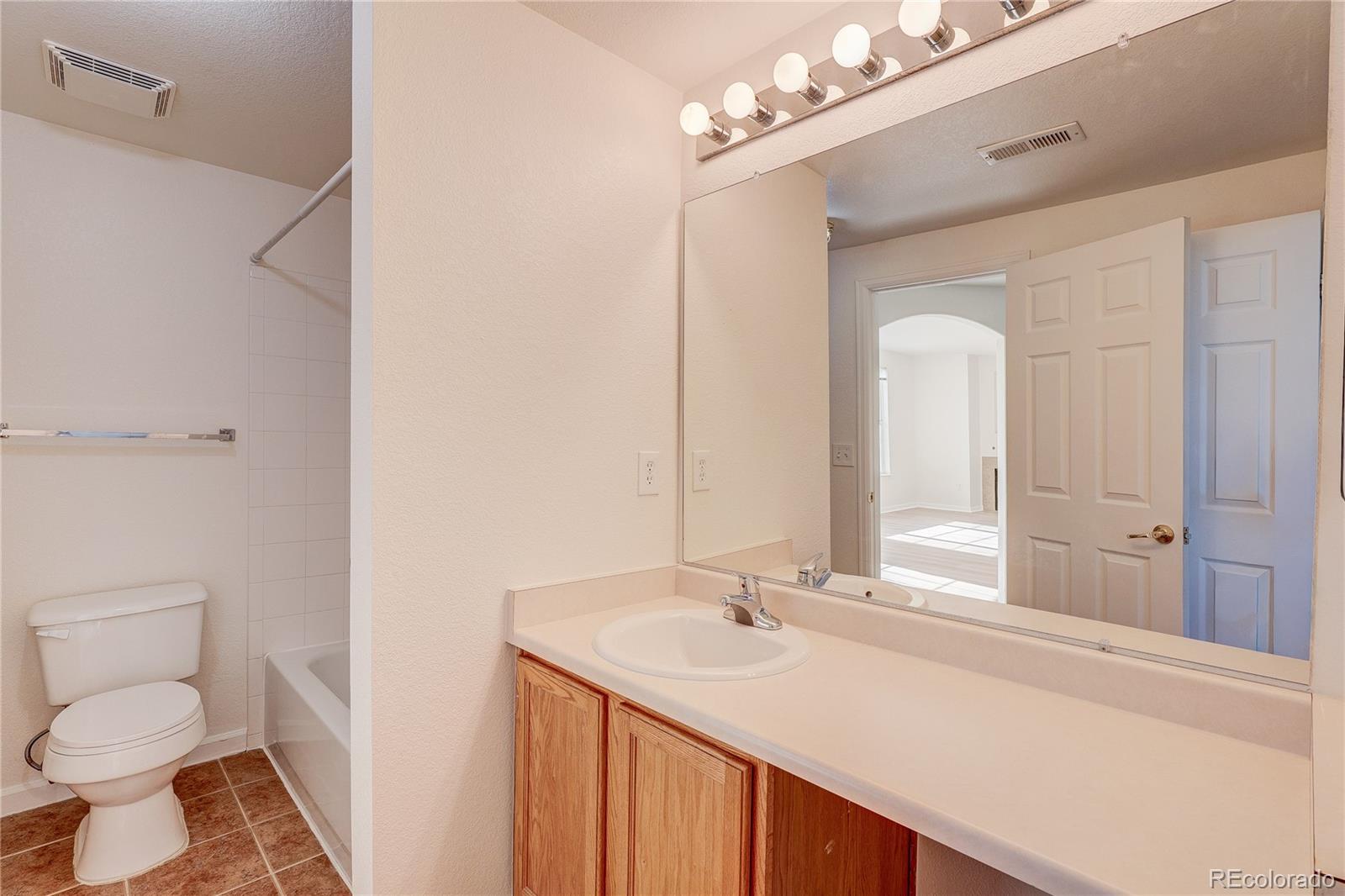 5756 North Genoa Way, Unit 12208 Aurora, CO 80019 - Photo 20 of 33 a bathroom with a sink vanity granite toilet and a mirror