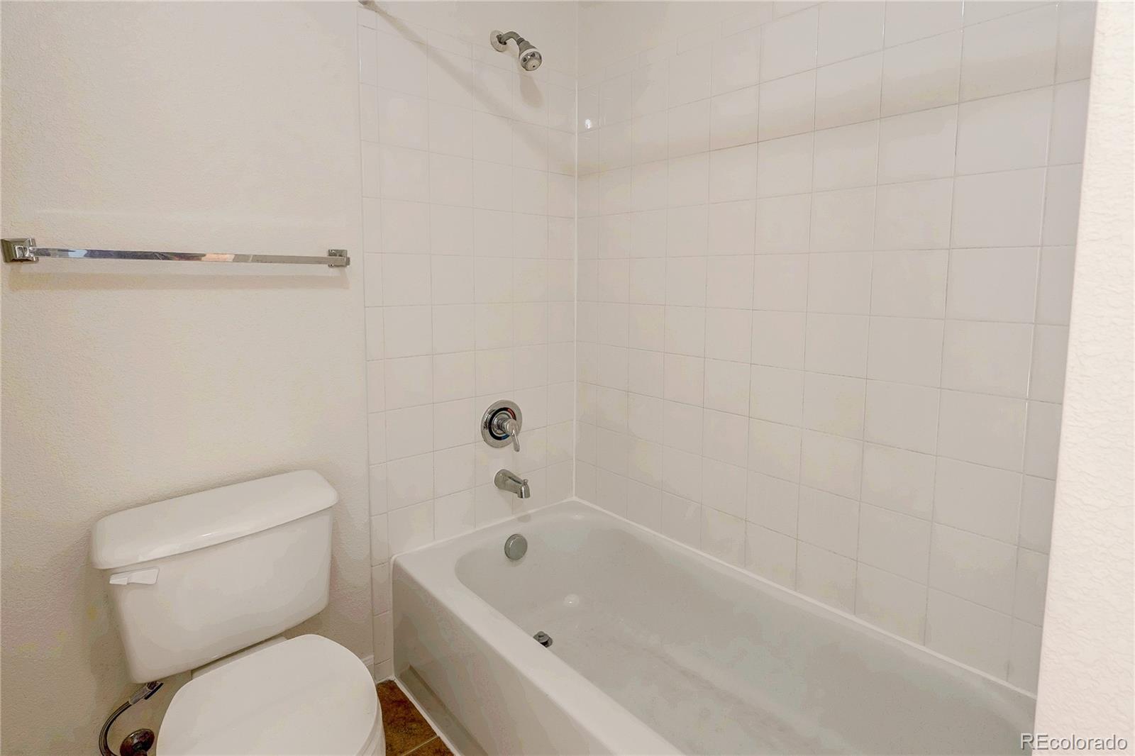 5756 North Genoa Way, Unit 12208 Aurora, CO 80019 - Photo 21 of 33 a white toilet sitting next to a bath tub