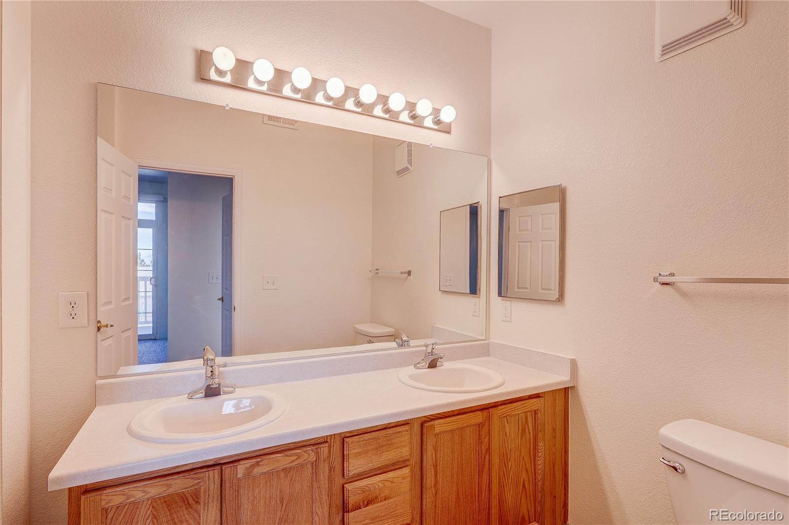 5756 North Genoa Way, Unit 12208 Aurora, CO 80019 - Photo 28 of 33 a bathroom with a sink and a mirror