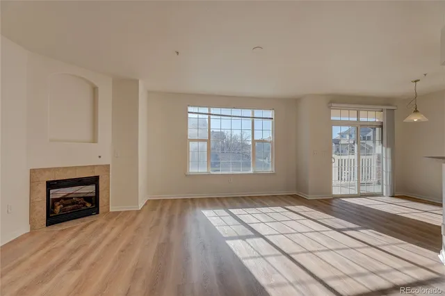 wooden floor fireplace and windows in an empty room
