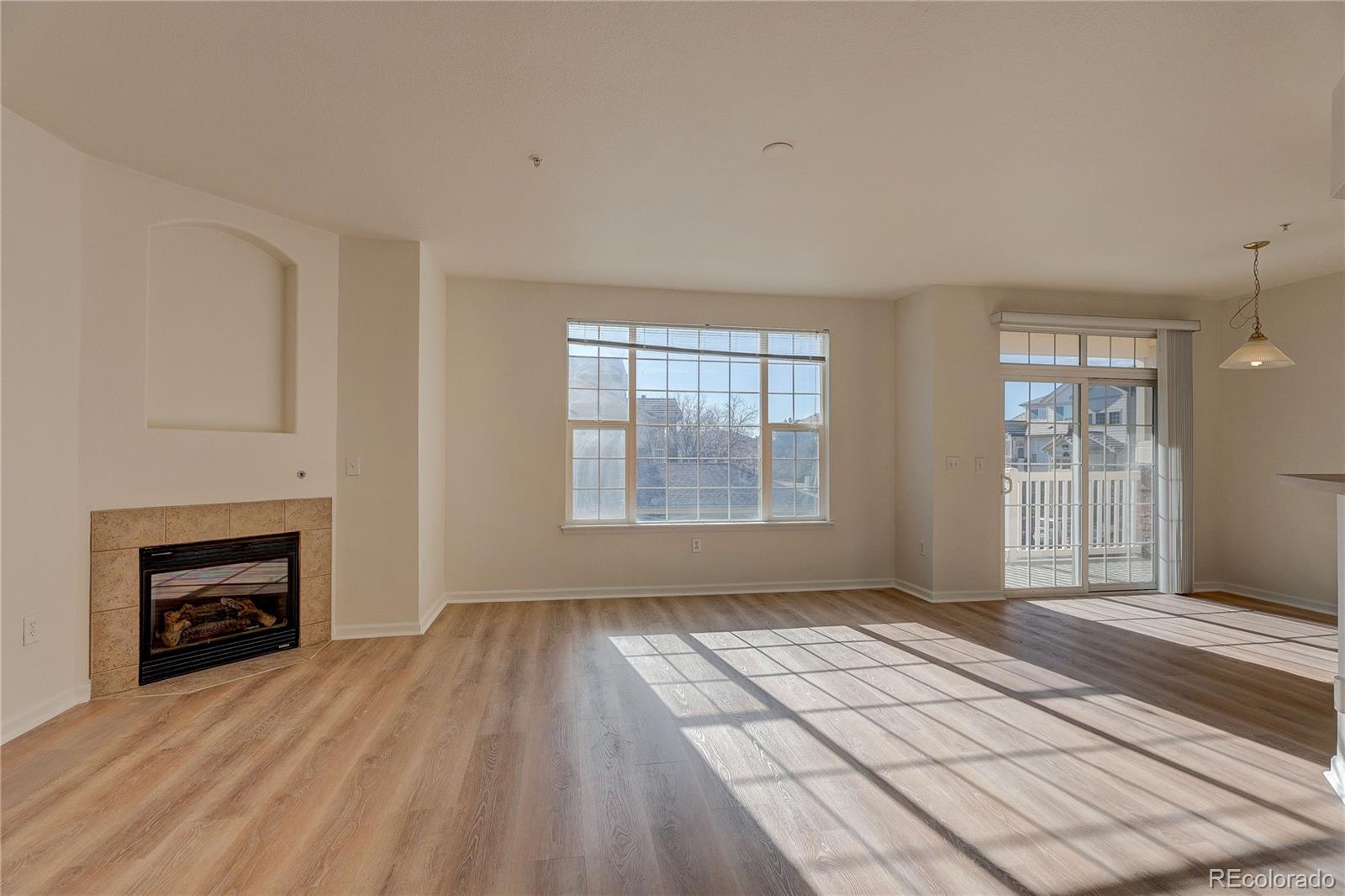 5756 North Genoa Way, Unit 12208 Aurora, CO 80019 - Photo 4 of 33 wooden floor fireplace and windows in an empty room