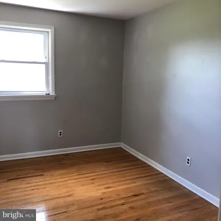 a view of a room with wooden floor and window