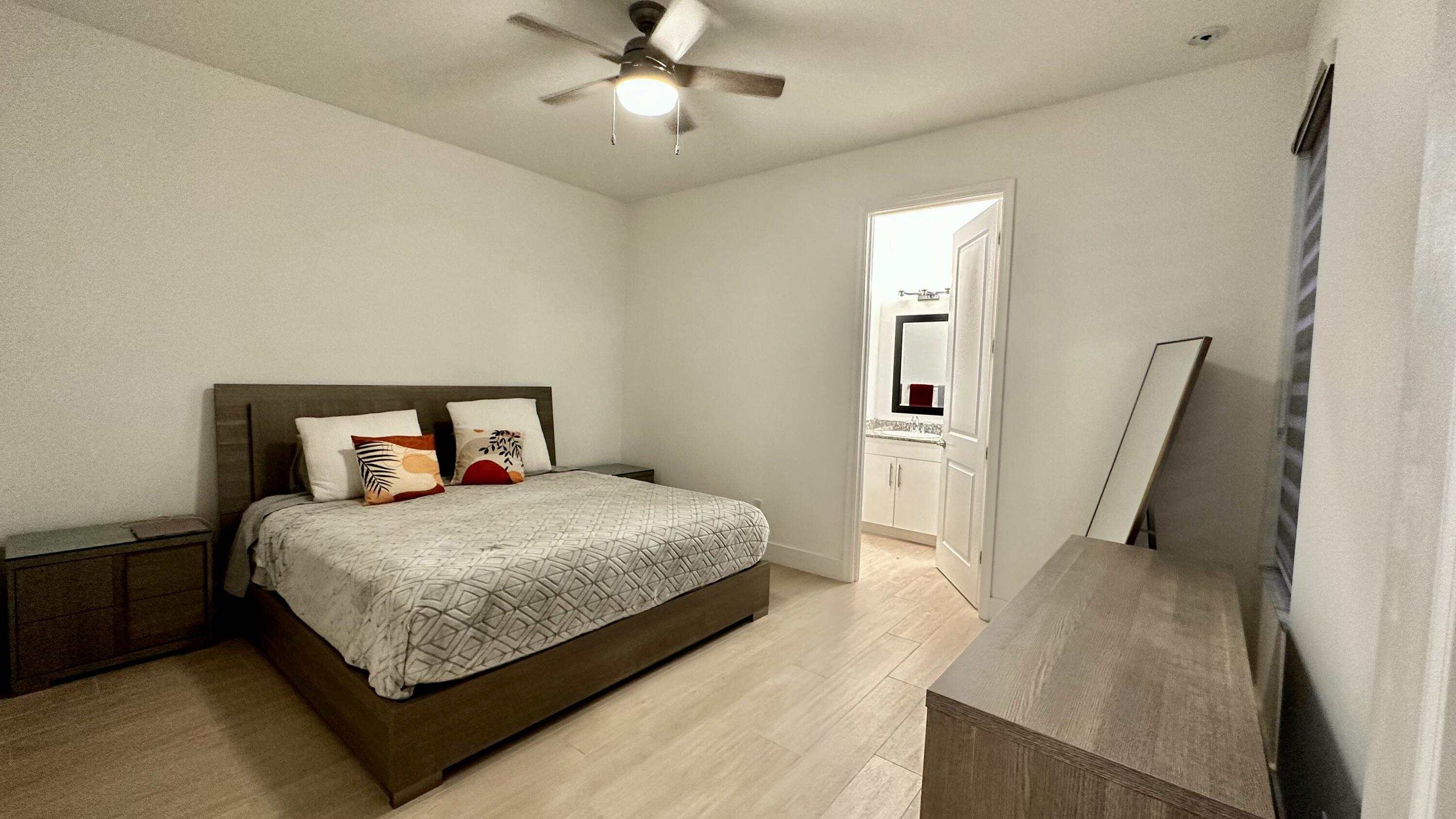 5570 Quiet Lake Place Westlake, FL 33470 - Photo 13 of 18 a bedroom with a bed and a chandelier