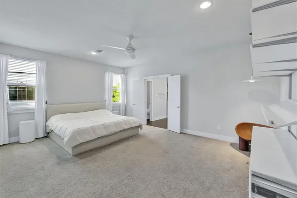 a spacious bedroom with a bed and window