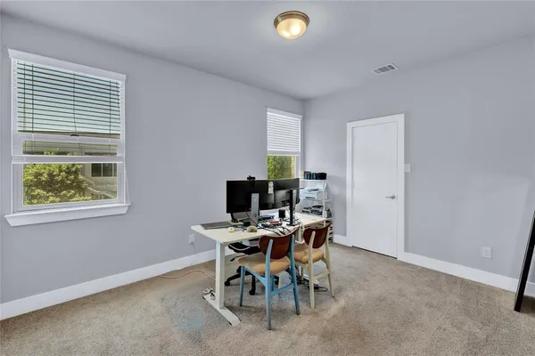 a view of a workspace with furniture and a window