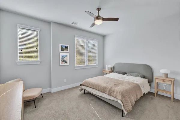 a bedroom with a bed a chandelier and a window