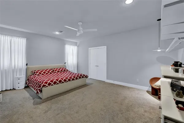 a spacious bedroom with a bed and a lamp