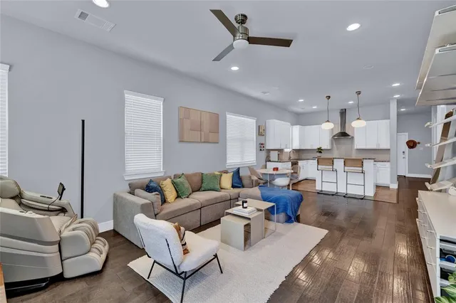 a living room with furniture and a view of kitchen