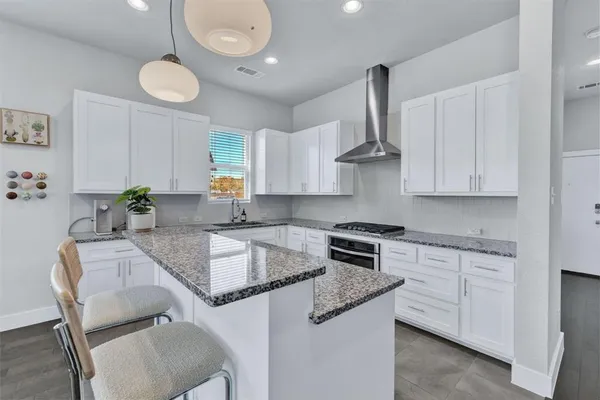 a kitchen with granite countertop a sink stove and cabinets