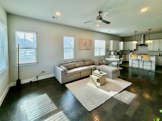 a living room with furniture and a wooden floor
